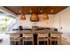 Outdoor kitchen with bar seating under a stylish wood-paneled ceiling at 531 68Th St, Holmes Beach, FL 34217