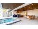 Luxurious covered patio with outdoor kitchen, dining, and a sparkling pool at 531 68Th St, Holmes Beach, FL 34217