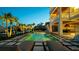 Luxury outdoor pool and entertainment area with plush lounge chairs and lush tropical landscaping at twilight at 531 68Th St, Holmes Beach, FL 34217