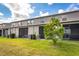 Backyard with lawn and screened patio, featuring well-maintained landscaping at 10642 Lake Montauk Dr, Riverview, FL 33578
