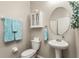 Stylish half bathroom featuring a pedestal sink, oval mirror, and decorative hanging towels at 10642 Lake Montauk Dr, Riverview, FL 33578