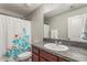 Bathroom with single sink vanity, decorative shower curtain, and neutral tones at 10642 Lake Montauk Dr, Riverview, FL 33578