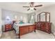 Cozy bedroom showcasing a wooden bed frame, matching dresser, and bright window at 10642 Lake Montauk Dr, Riverview, FL 33578