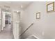 Bright hallway featuring neutral tones and stylish wall decor leading to carpeted staircase at 10642 Lake Montauk Dr, Riverview, FL 33578