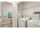 Functional laundry room with a washer, dryer, and storage shelves for efficient organization at 10642 Lake Montauk Dr, Riverview, FL 33578