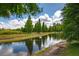 Scenic view of a community pond surrounded by lush greenery and a clear blue sky at 10642 Lake Montauk Dr, Riverview, FL 33578