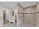 Bathroom featuring neutral tile walk-in shower with glass door and dual shower heads at 11447 Adelia St, Spring Hill, FL 34608