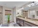 Bathroom featuring a dual sink vanity with granite counters, and large window at 11447 Adelia St, Spring Hill, FL 34608