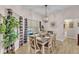 Dining room with a wooden table set for six, with natural light and a view of the backyard pool at 11447 Adelia St, Spring Hill, FL 34608