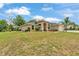 Beautiful single-story home with a three-car garage, arched entry, and lush green lawn at 11447 Adelia St, Spring Hill, FL 34608