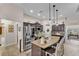 Modern kitchen features stainless steel appliances, a granite island with bar seating, and stylish pendant lighting at 11447 Adelia St, Spring Hill, FL 34608
