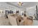 Open-concept living area featuring a large sectional sofa, ceiling fan, and views into the kitchen and entryway at 11447 Adelia St, Spring Hill, FL 34608