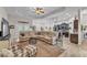 Spacious living room with a comfortable sectional sofa, ceiling fan, and an open concept design to the kitchen at 11447 Adelia St, Spring Hill, FL 34608