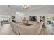 Expansive living room with a sectional sofa, entertainment center, and views into the office, entryway, and bedroom at 11447 Adelia St, Spring Hill, FL 34608