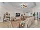 Comfortable living room with a large sectional sofa, ceiling fan, entertainment center, and stylish decor at 11447 Adelia St, Spring Hill, FL 34608