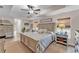 Bright main bedroom features wood-look floors, ceiling fan, and view of windows at 11447 Adelia St, Spring Hill, FL 34608