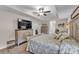 Spacious main bedroom with tray ceiling, ceiling fan, sitting area, and large television at 11447 Adelia St, Spring Hill, FL 34608