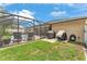 Screened-in pool area with outdoor seating, grill, and lush green lawn at 11447 Adelia St, Spring Hill, FL 34608