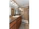 Bathroom featuring granite countertop, framed mirror, and a glass shower at 12654 Belcroft Dr, Riverview, FL 33579