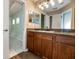 Bright bathroom with a long wood vanity, granite counters, large mirror and multiple lights at 12654 Belcroft Dr, Riverview, FL 33579