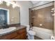 Well-lit bathroom featuring a granite-topped vanity, a bathtub with tiled walls and dark fixtures at 12654 Belcroft Dr, Riverview, FL 33579