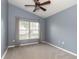 Blue bedroom with a large window, a ceiling fan and neutral carpeted floors throughout at 12654 Belcroft Dr, Riverview, FL 33579