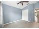 Large blue bedroom with carpeted floor, a double door closet and ceiling fan overhead at 12654 Belcroft Dr, Riverview, FL 33579