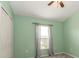 Light green bedroom with large window and standard closet with a ceiling fan overhead at 12654 Belcroft Dr, Riverview, FL 33579