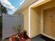 Close-up of the home's entrance featuring a yellow door, well-maintained yard and white privacy fence at 12654 Belcroft Dr, Riverview, FL 33579