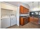 Kitchen featuring stainless steel appliances, wooden cabinets, and washer and dryer at 12654 Belcroft Dr, Riverview, FL 33579