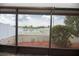 Screened-in patio area offering views of the manicured backyard, white picket fence, and pond at 12654 Belcroft Dr, Riverview, FL 33579