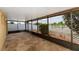 Enclosed patio with a stone floor and screened windows overlooking the backyard and pond at 12654 Belcroft Dr, Riverview, FL 33579