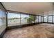 Enclosed patio featuring a stone-patterned floor, screened windows, and views of the backyard and neighborhood at 12654 Belcroft Dr, Riverview, FL 33579