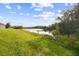 Beautiful scenic view of a grassy backyard with a peaceful pond at 15354 Sweet Springs Bnd, Odessa, FL 33556