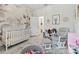 Bedroom with floral wallpaper, a crib, and a glider at 15354 Sweet Springs Bnd, Odessa, FL 33556