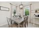 Charming dining room with a modern chandelier, a wooden table, and views of the lush backyard at 15354 Sweet Springs Bnd, Odessa, FL 33556