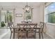 Cozy dining area with a modern light fixture, a wood table, and natural light from the windows at 15354 Sweet Springs Bnd, Odessa, FL 33556
