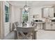 Bright dining room with gray wood table, updated lighting, and views of the backyard at 15354 Sweet Springs Bnd, Odessa, FL 33556