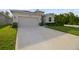 Long driveway leading to a well-maintained home with a two-car garage and lush landscaping at 15354 Sweet Springs Bnd, Odessa, FL 33556