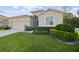 View of a home's exterior with a lush green lawn, a paved driveway, and a two-car garage at 15354 Sweet Springs Bnd, Odessa, FL 33556