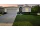 Charming single-story home featuring a two-car garage, manicured lawn, and inviting front entrance at 15354 Sweet Springs Bnd, Odessa, FL 33556