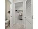 Hallway leading to a bathroom, showing the tile floor and closet at 15354 Sweet Springs Bnd, Odessa, FL 33556