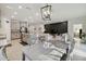 Bright, open-concept living area with a modern light fixture, gray cabinets, and a stylish accent wall at 15354 Sweet Springs Bnd, Odessa, FL 33556