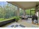 Large screened porch with seating, a grill, and scenic views of the lush, green landscape at 15354 Sweet Springs Bnd, Odessa, FL 33556