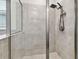 Walk-in shower featuring gray tiling, glass door and modern showerhead at 15354 Sweet Springs Bnd, Odessa, FL 33556