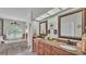 Bathroom featuring dual vanity, soaking tub under arch window, and wood cabinets for a comfortable experience at 2912 Aston Ave, Plant City, FL 33566