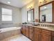 Luxurious bathroom featuring double vanities, a soaking tub, and natural light at 3620 Cordgrass Dr, Valrico, FL 33596
