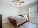 Comfortable bedroom with a ceiling fan, wood-look flooring, and a double-hung window at 3620 Cordgrass Dr, Valrico, FL 33596