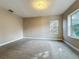 This bedroom is well-lit by its double hung window and features neutral carpet and paint at 3620 Cordgrass Dr, Valrico, FL 33596
