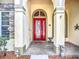 Arched entryway with a red front door and decorative accents provides a welcoming entrance at 3620 Cordgrass Dr, Valrico, FL 33596